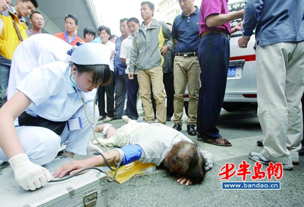 面包车拐弯刮倒老太卷入车底 众人抬车救人_面