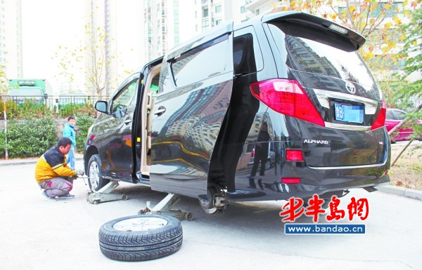 一辆丰田埃尔法商务车正在换胎.高清图片