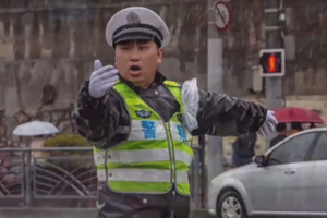 早高峰堵车严重 雨中“浇”警暖人心