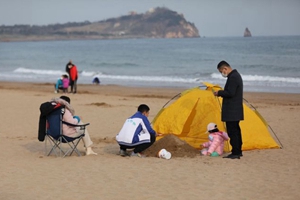 青岛石老人海水浴场：趁着好天气 市民惬意游